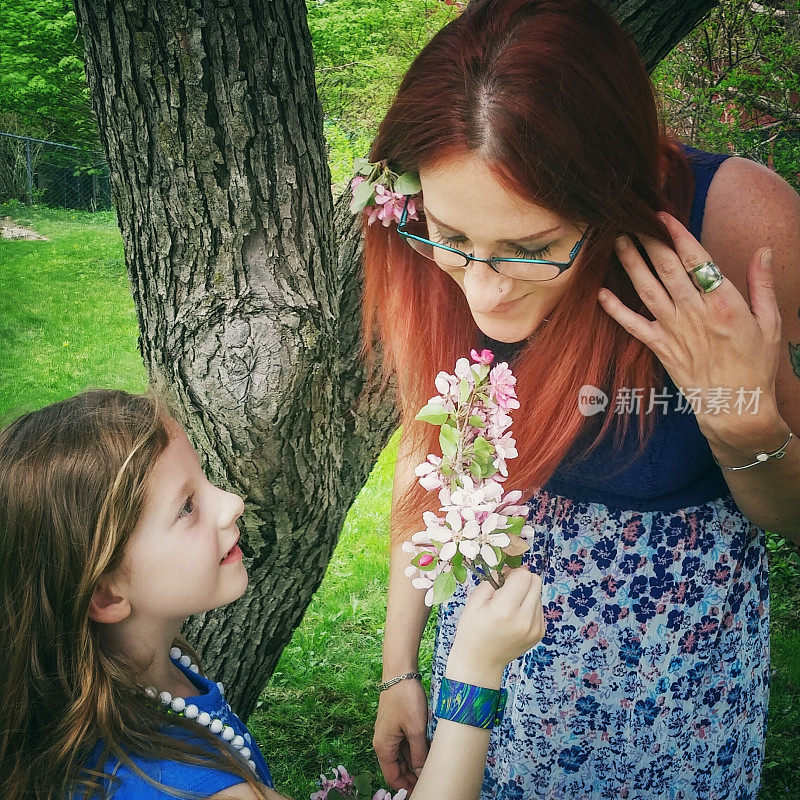 Young Daughter Holds Mother's Day Spring Flowers, Mother Smelling